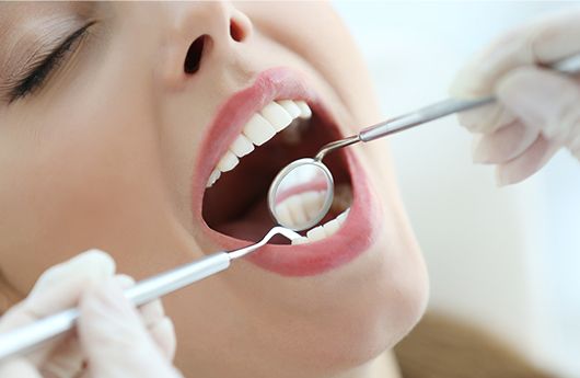 Dentist checking patient's tooth-colored fillings
