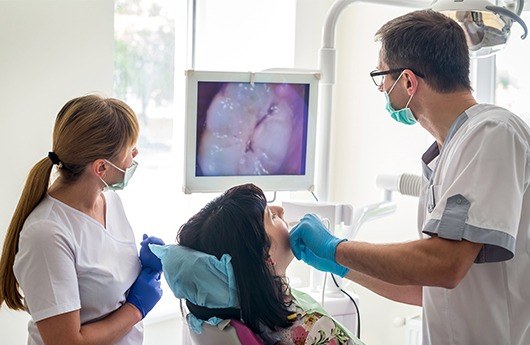 Dentist team member and dental patient looking at intraoral images