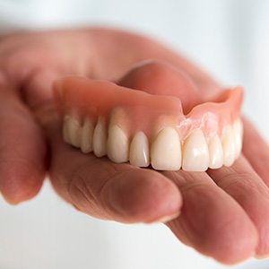 person holding dentures