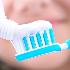 Closeup of toothpaste being squeezed onto toothbrush